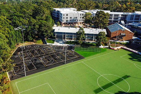 Aerial view with Chatswood High School buildings in background and sports field in foreground