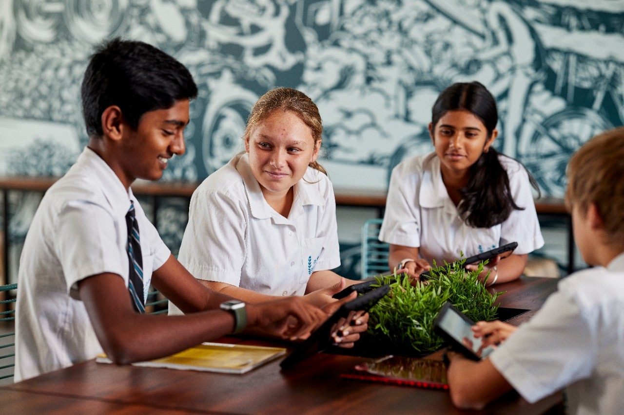 A group of students looking at a tablet