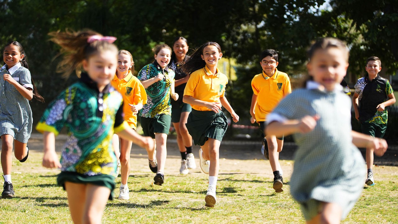 A group of students running together outdoors. 
