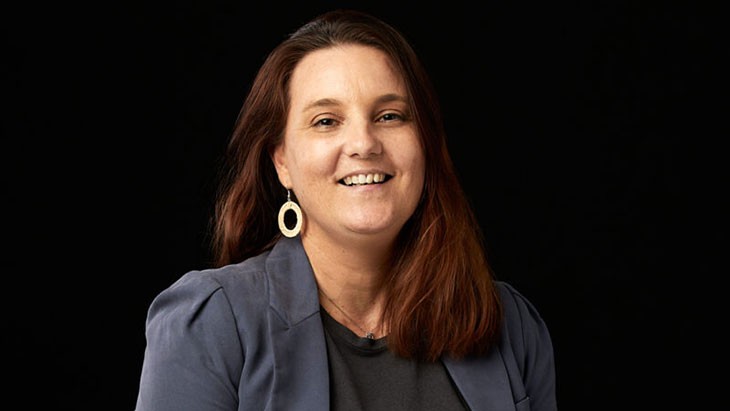 Photo of Kristin Sheldon from the shoulders up against a black background