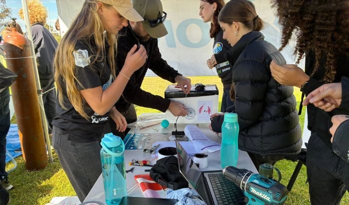 Two young women around a desk and making preparations to launch a weather balloon