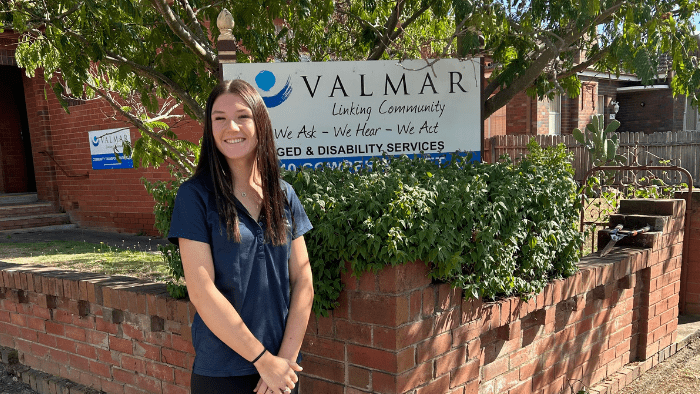 Goulburn student Isla Rae smiles at camera while standing in front of aged care facility