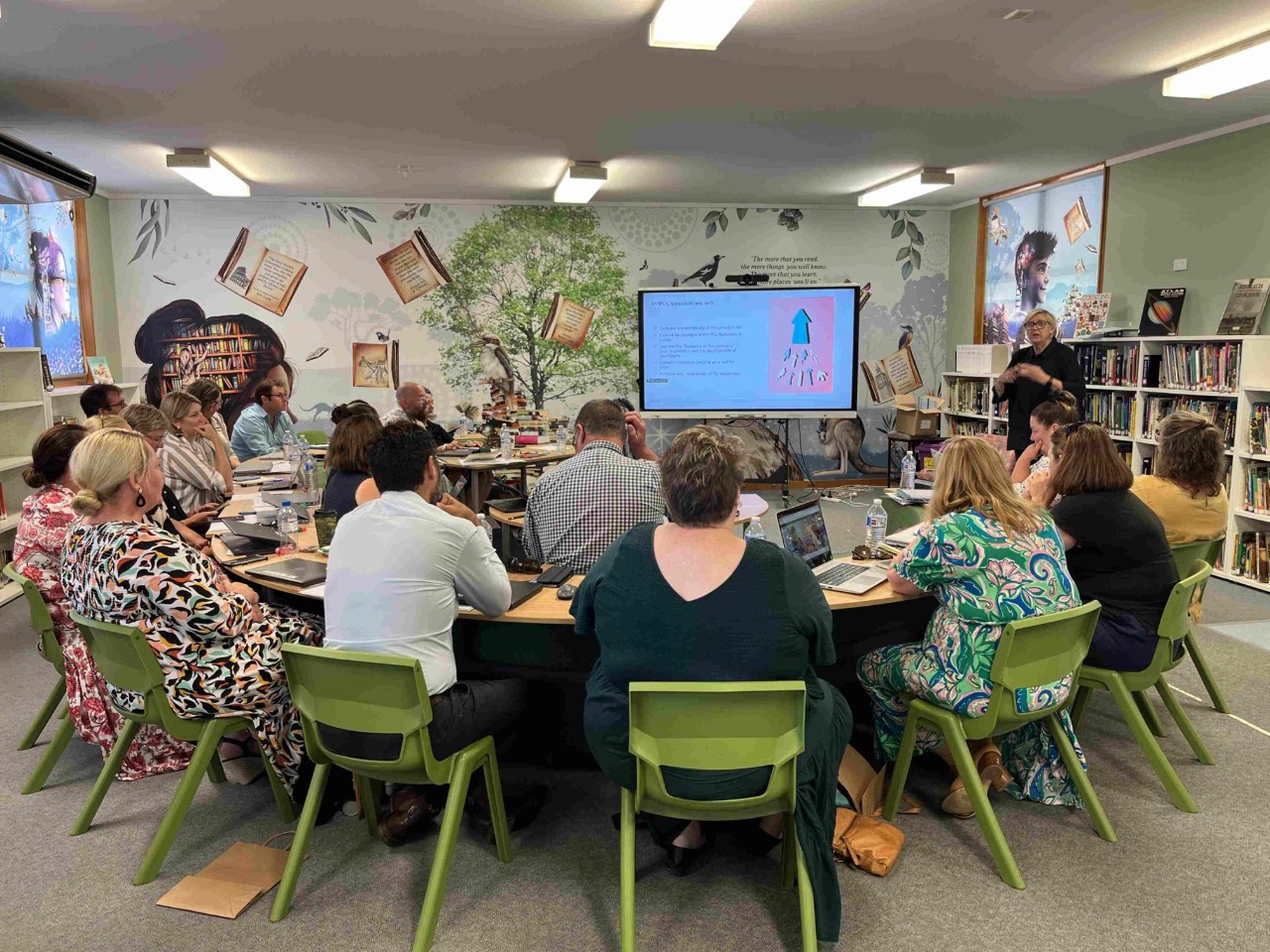 A group of principals listen to a presentation by the SLI team.