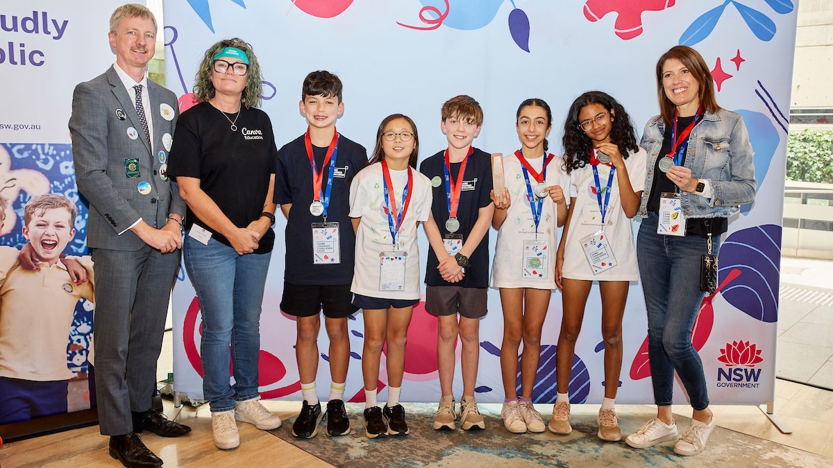 Adult male and female stand next to five students and an adult female wearing medals.