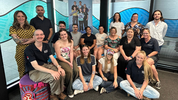 A group of young people from all walks of life in front of a NSW Training Awards 2025 banner.