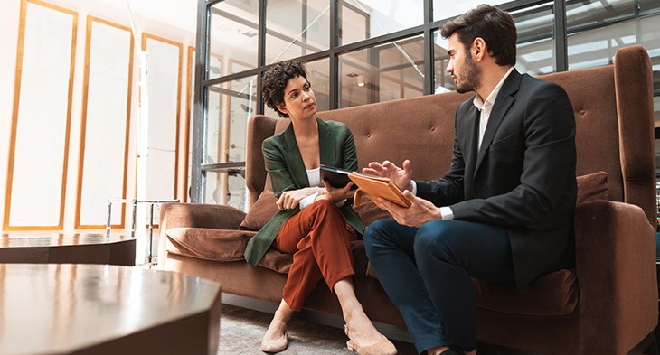Male and female on couch having a discussion.