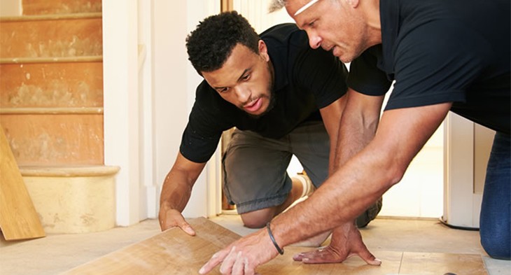 Apprentice carpenter with supervisor working on new floor.