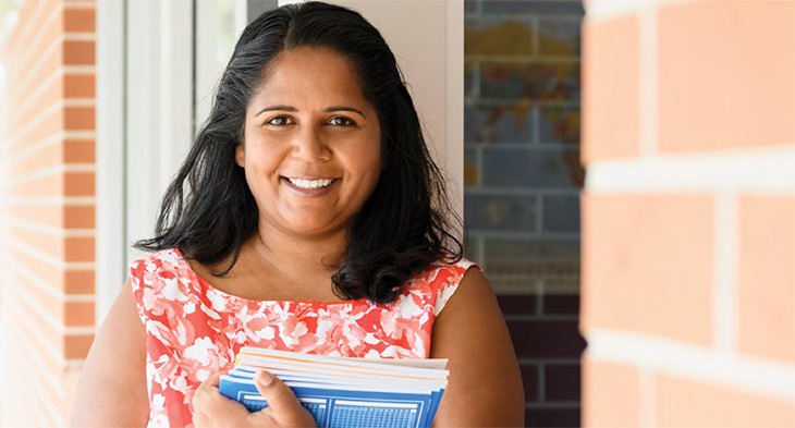 Aboriginal woman with books smiling