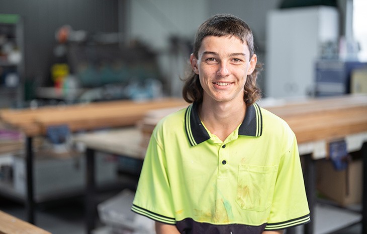 A male carpentry student in the workshop