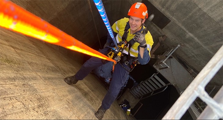 Construction worker in harness wearing PPE.