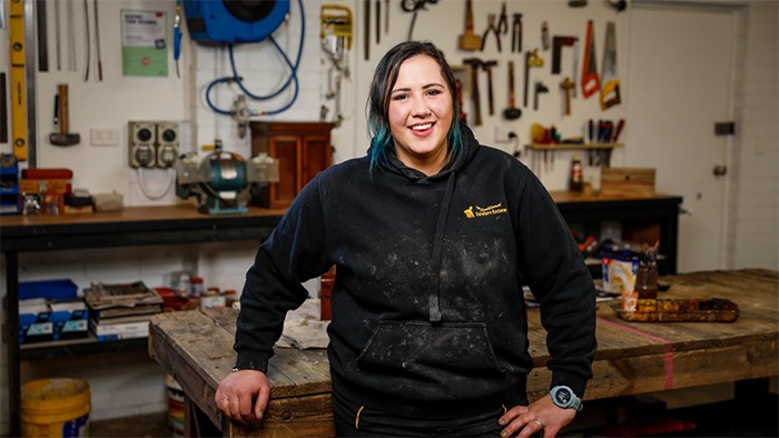 Female carpentry apprentice in workshop.