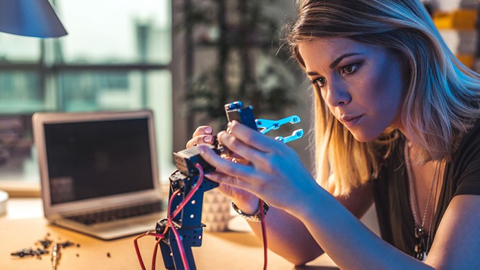 Female electronics apprentice working on a project