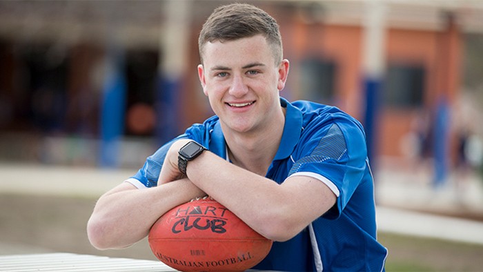 Healthy male fitness coach with football.