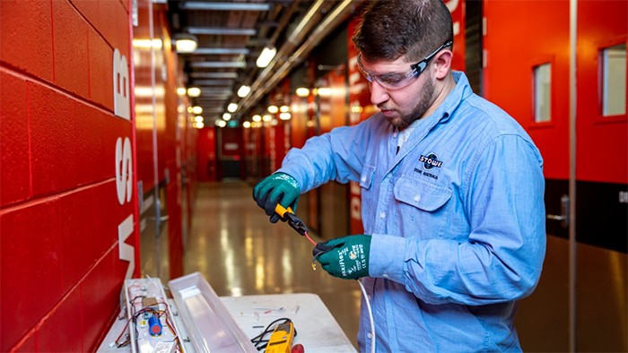 Male electronics apprentice working with PPE