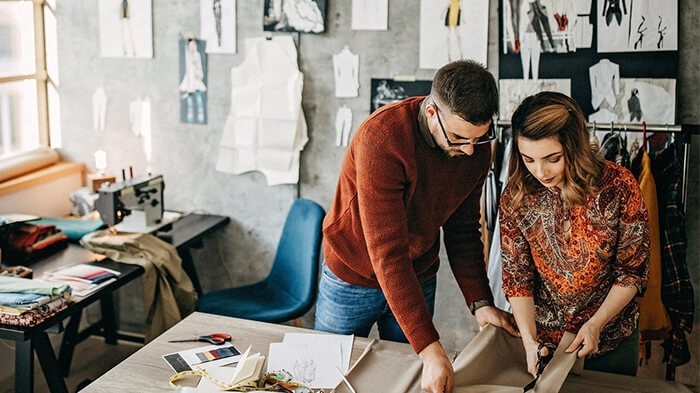 Fashion designers working with fabrics.