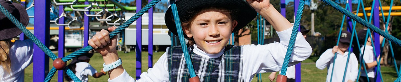 Young student climbing play equipment
