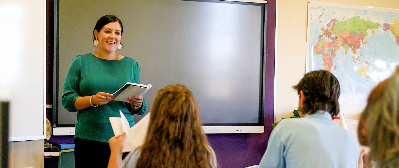 Female teacher standing in front of class teaching