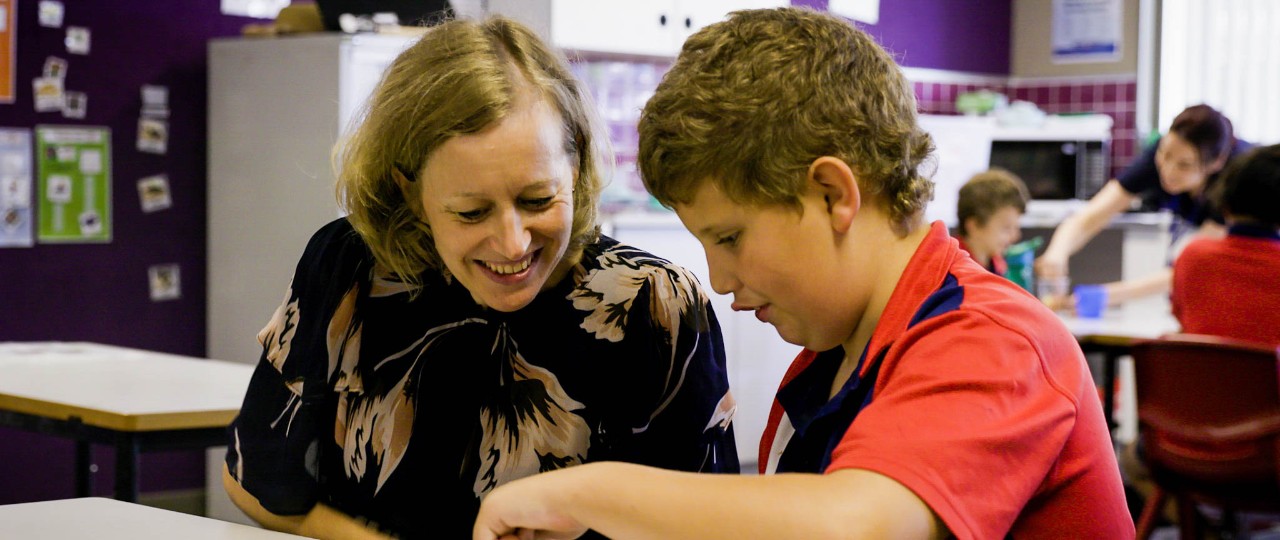 Female teacher helping student with work