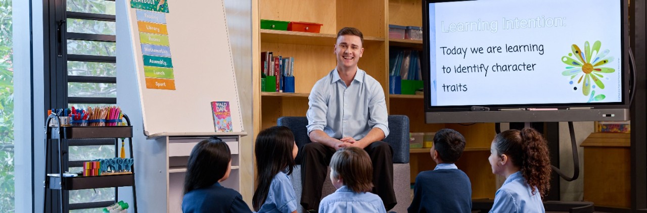 Male teacher smiles to camera 