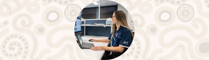 Amazon Web Services Workplace Learning for Aboriginal and Torres Strait Islander students showing a female Aboriginal student in an office working in front of a computer.