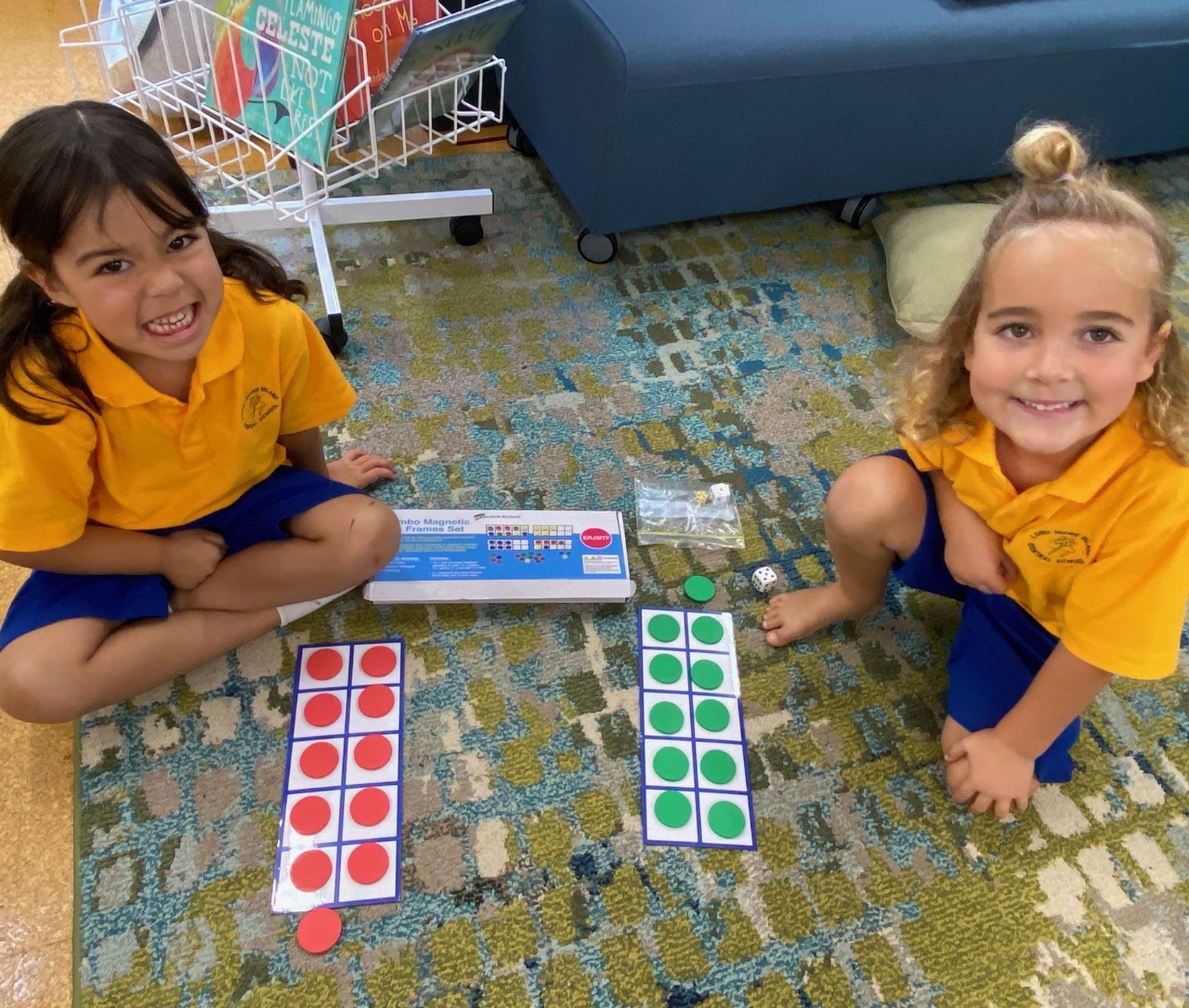 Two students sitting on the floor of a classroom working with ten frames