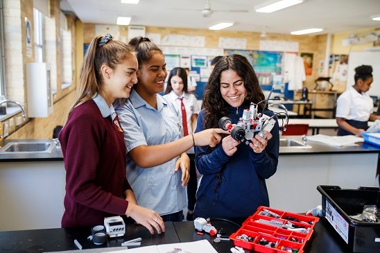 Three students holding a mechanical object