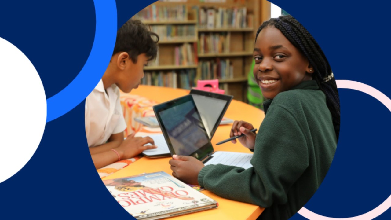 Students smiling and using a laptop