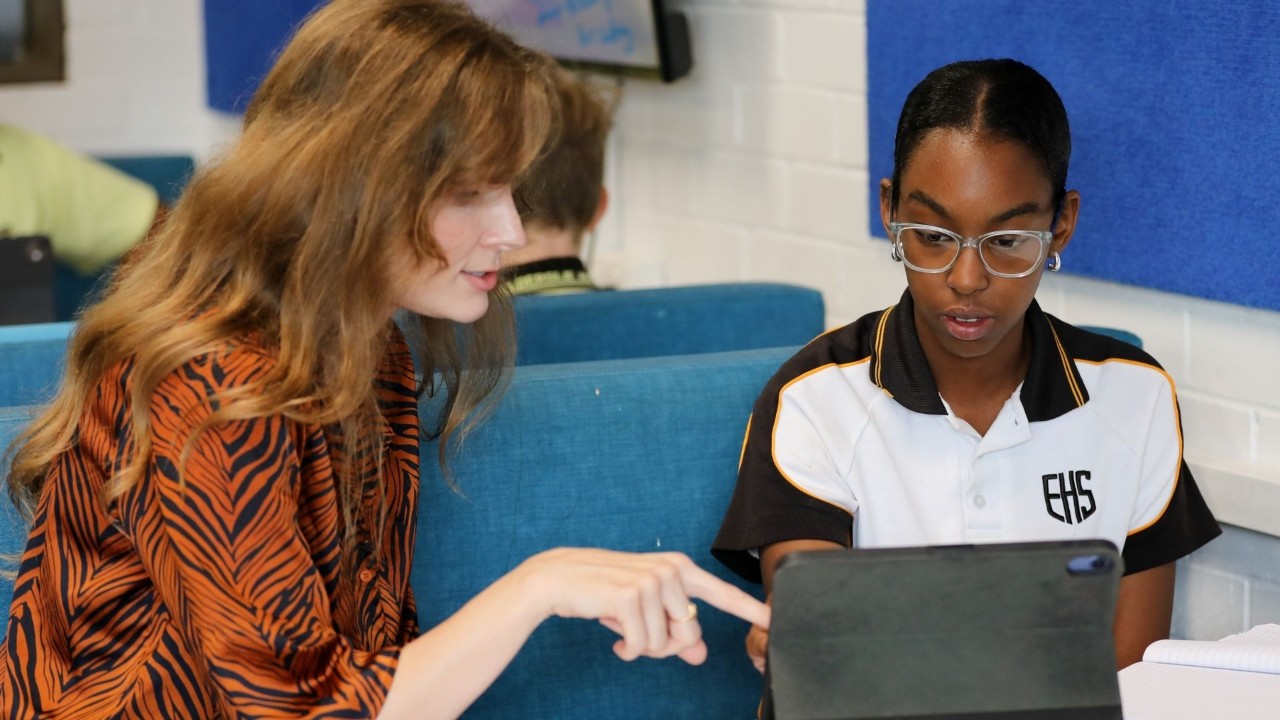 A teacher working with her student on her iPad