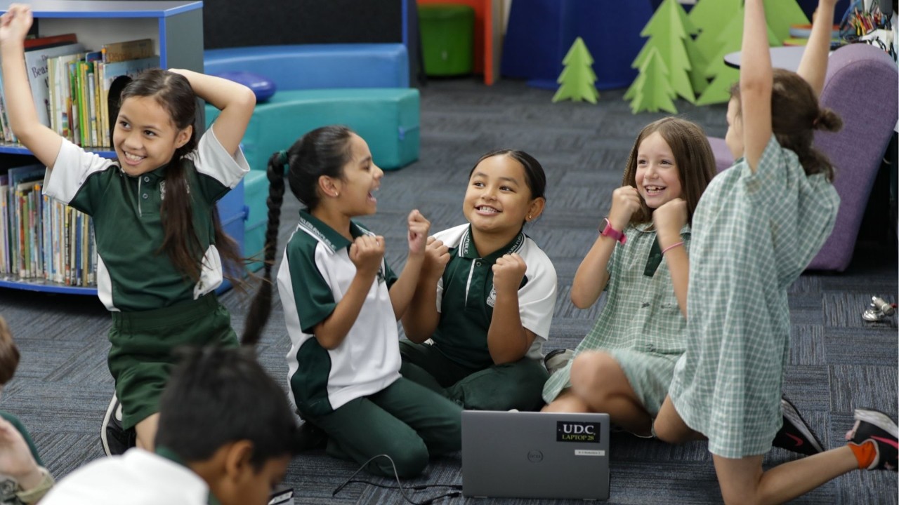 A group of students surrounding a laptop