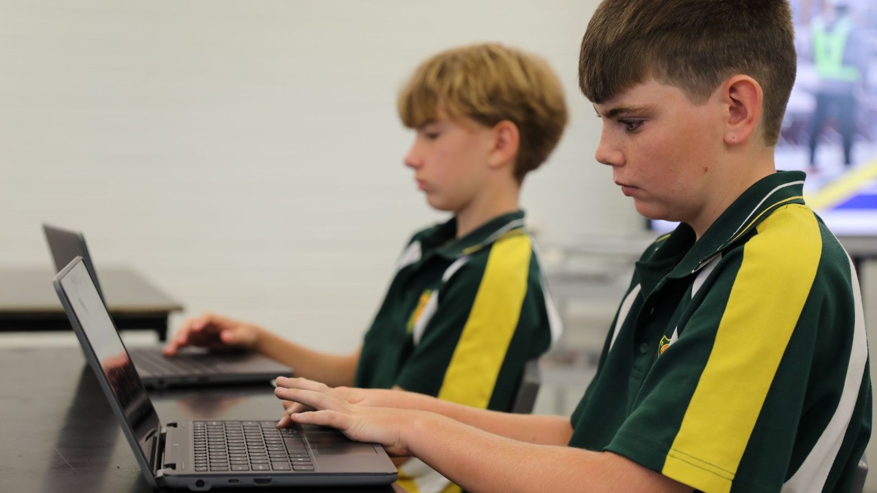 Students sitting and working on a laptop.