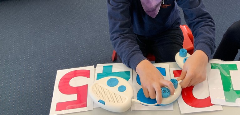 Student sitting at a table using the Code Jumper hardware.