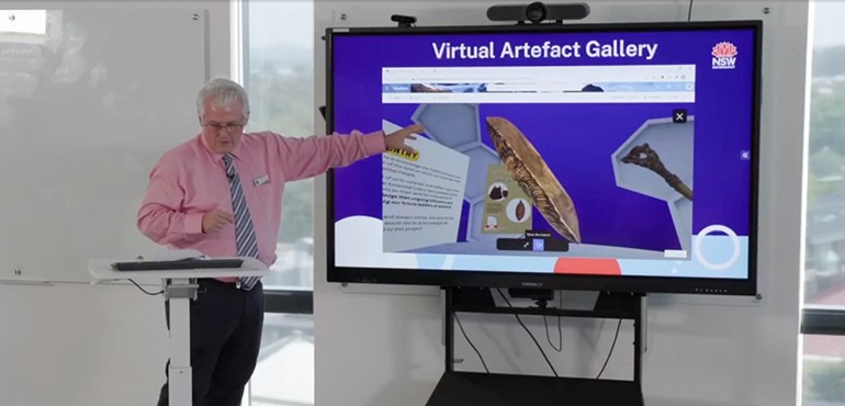 Michael discussing a virtual Aboriginal art gallery on a smart board.