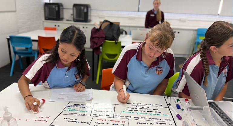 Two students writing on whiteboard